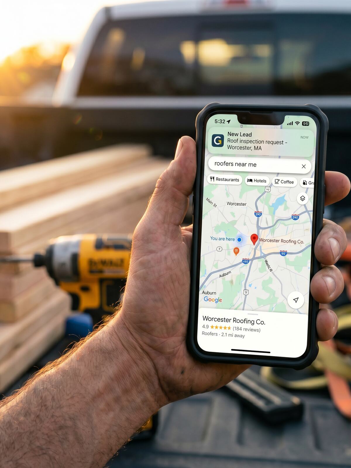 Um empreiteiro de Massachusetts verifica no celular um resultado do Google Maps referente a um trabalho no condado de Worcester, com uma caminhonete e ferramentas ao fundo.